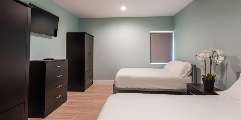 Shared bedroom with two beds, furniture, and a TV.