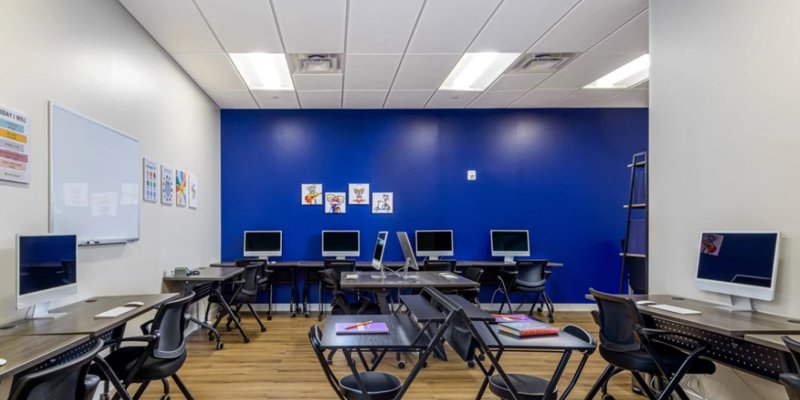 Classroom equipped with computers and desks.
